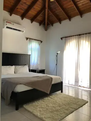 a bedroom with a bed and a large window at Villa twin palm in Sosúa
