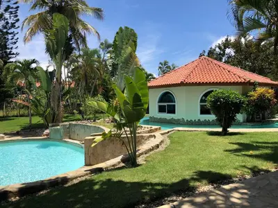 a villa with a swimming pool and a house at Villa twin palm in Sosúa