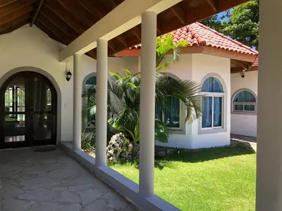 a house with a palm tree in the yard at Villa twin palm in Sosúa