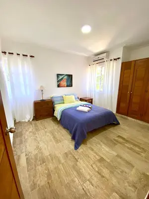 a bedroom with a bed with a blue blanket at Vista del Sol Pool and Beach los Corales Rd in Punta Cana