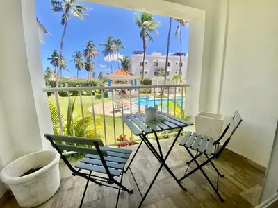 a balcony with a table and chairs and a view of the pool at Vista del Sol Pool and Beach los Corales Rd in Punta Cana