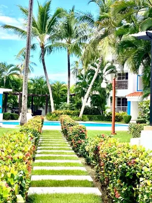 a pathway in front of a resort with palm trees at Vista del Sol Pool and Beach los Corales Rd in Punta Cana