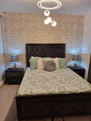 a bedroom with a large bed with two night stands at Luna airport retreat in Boca Chica