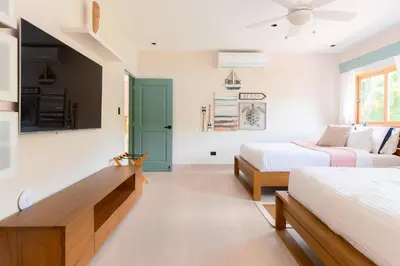 a bedroom with two beds and a tv on the wall at New! Gorgeous Portillo Beach Villa W Pool & Staff in Abra Grande