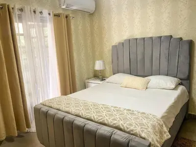 a bed with a gray headboard in a bedroom at Colonial leyton apartment in Santo Domingo