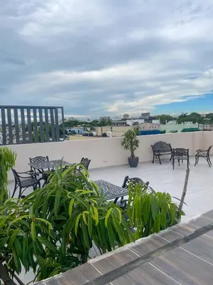 a patio with tables and chairs on a roof at Colonial leyton apartment in Santo Domingo