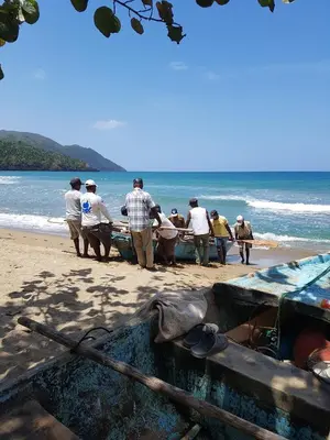a group of people holding onto boats on the beach at Villa Los Gorgones in Las Galeras