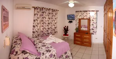 a bedroom with a bed and a dresser and a mirror at Residencial Estephany in Sosúa