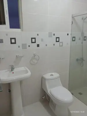 a white bathroom with a toilet and a sink at Residencial Estephany in Sosúa