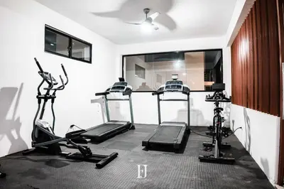 a gym with three tread machines in a room at Fj Luxury Apartment in Santiago de los Caballeros