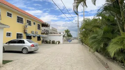 a car parked in front of a yellow building at Estancia Marina 101 in Boca Chica