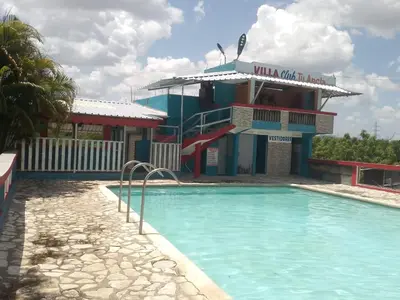 a resort with a swimming pool in front of a building at Villa club turístico tu ancla in Los Alcarrizos