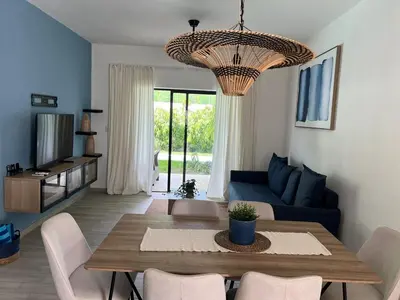 a living room with a table and a blue couch at Swim up and Beach Getaway at White Sands in Punta Cana