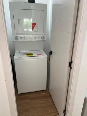a small white washer and dryer in a room at Swim up and Beach Getaway at White Sands in Punta Cana