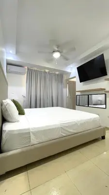 a bedroom with a large bed with a flat screen tv at Relaxing and cozy apartment in Gazcue in Santo Domingo