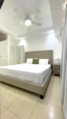 a bedroom with a large white bed with a ceiling at Relaxing and cozy apartment in Gazcue in Santo Domingo