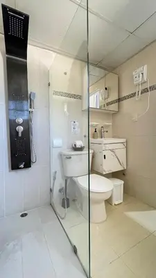 a bathroom with a toilet and a glass shower at Relaxing and cozy apartment in Gazcue in Santo Domingo