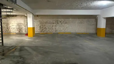 an empty parking garage with yellow and white columns at Relaxing and cozy apartment in Gazcue in Santo Domingo