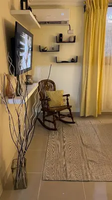 a living room with a bench and a tv at Apartamento cerca de todo en SDE in Santo Domingo