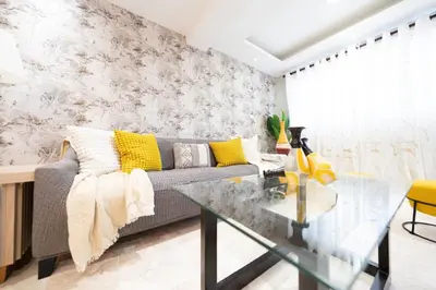 a living room with a couch and a glass table at City Center, 2-BR Suite close to Shops, Restaurants, Bars and More in Santo Domingo