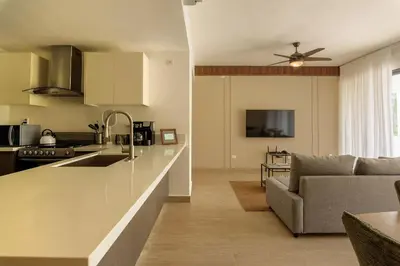 a kitchen and living room with a sink and a couch at PB 3 hab | con piscina privada + laguna cristalina in Punta Cana