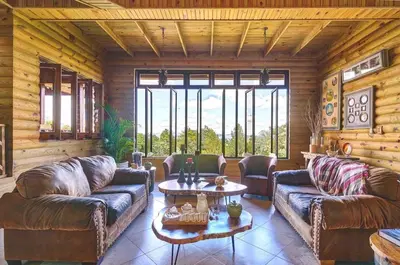 a living room with leather couches and a table at ®4BR{Wood~Mountain~Villa} @Jarabacoa Heated Pool in Jarabacoa