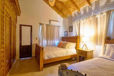a bedroom with two beds and a mirror at ®4BR{Wood~Mountain~Villa} @Jarabacoa Heated Pool in Jarabacoa