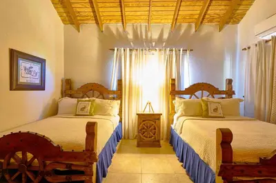 a bedroom with two beds and a window at ®4BR{Wood~Mountain~Villa} @Jarabacoa Heated Pool in Jarabacoa