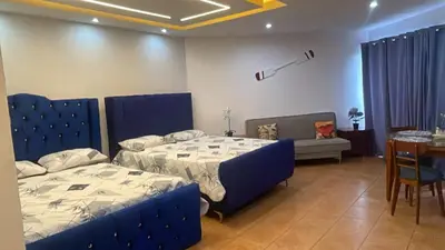 a bedroom with two beds and a table and a tableablish at Atardecer Albatros in Juan Dolio