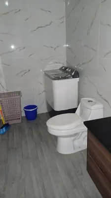 a bathroom with a white toilet and a counter at Atardecer Albatros in Juan Dolio