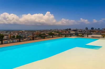 a large swimming pool on the roof of a building at Cozy 1BR Condo, Pool, Gym in Santo Domingo