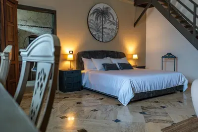 a bedroom with a large bed and a staircase at La Pala Suites in Las Terrenas