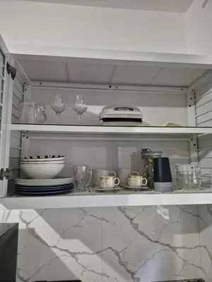 a kitchen shelf with dishes and glasses on it at ENE Apartments Nagua 1B in Nagua