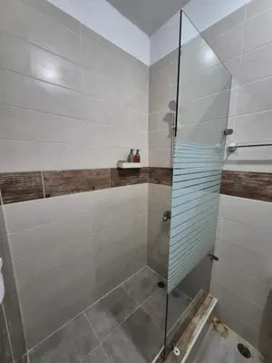 a shower with a glass door in a bathroom at ENE Apartments Nagua 1B in Nagua