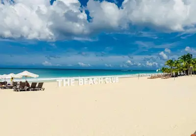 a beach with a sign that reads the beach club at Cana Rock Penthouse Golf Views & Infinity Pool in Punta Cana