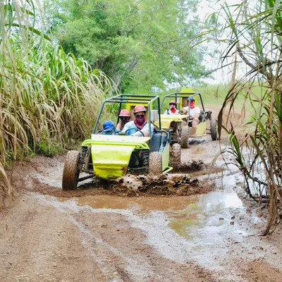 a group of people riding on a four wheeler through the mud at Cana Rock Penthouse Golf Views & Infinity Pool in Punta Cana