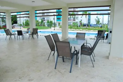 a dining room with a table and chairs and a pool at Amor in Punta Cana