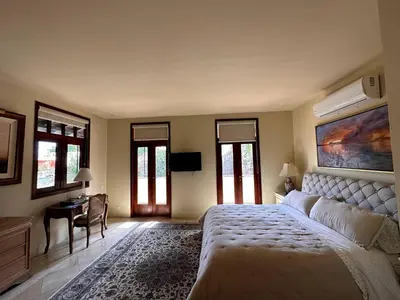 a bedroom with a bed and a desk and windows at Lux 2-Level Townhouse with Stunning Historic Views in Santo Domingo