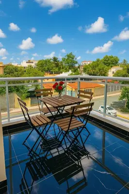 a wooden table and chairs on a balcony at Comfortable and Attractive Apartment in Ensanche Savica de Mendoza