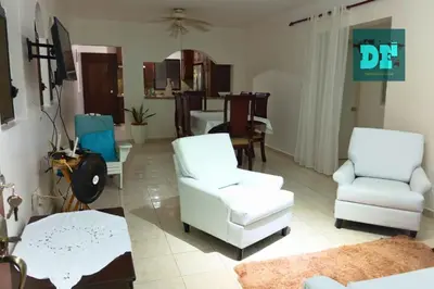 a living room with two white chairs and a table at Villa Eli in Puerto Plata