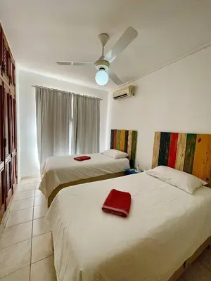 a bedroom with two beds and a ceiling fan at Apartment 5 Mins Walk To The Beach