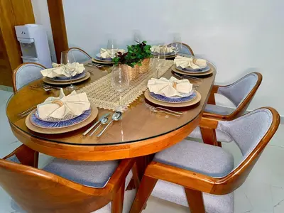 a dining room table with chairs and a wooden table with plates at Zarzuela Villas del Mar Puerto Plata in Muñoz