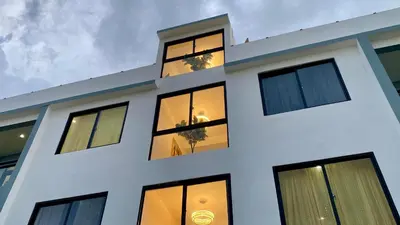 a white building with lights in the windows at Zarzuela Villas del Mar Puerto Plata in Muñoz