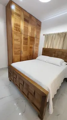 a bedroom with a large bed with a wooden headboard at Zarzuela Villas del Mar Puerto Plata in Muñoz