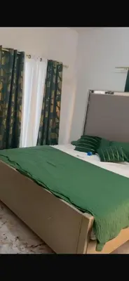 a bed with a green blanket on top of it at santo domingo airport villa in Reparto Esther Rosario