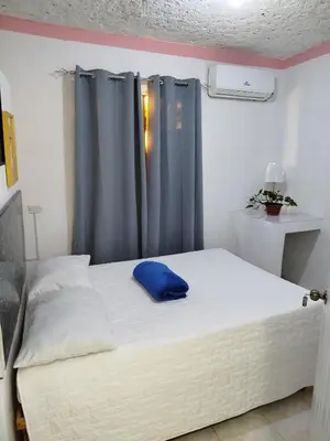 a bedroom with a bed with a blue pillow on it at Hotel El Almendro in Pedernales