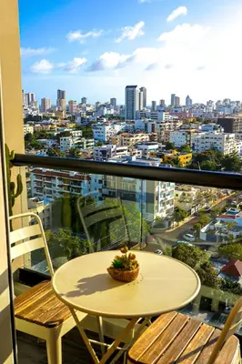 a table on a balcony with a view of a city at Elegant and Cozy 1BD Condo in Santo Domingo