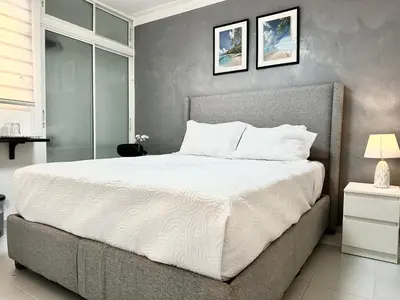 a bedroom with a large bed with white sheets at RoblestRoom in Santiago de los Caballeros