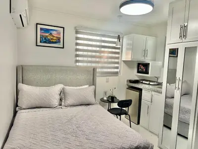 a small bedroom with a bed and a kitchen at RoblestRoom in Santiago de los Caballeros