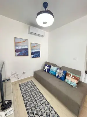 a living room with a couch and a television at apartamento exclusivo con jacuzzi, piscina y vista al lago in Las Terrenas